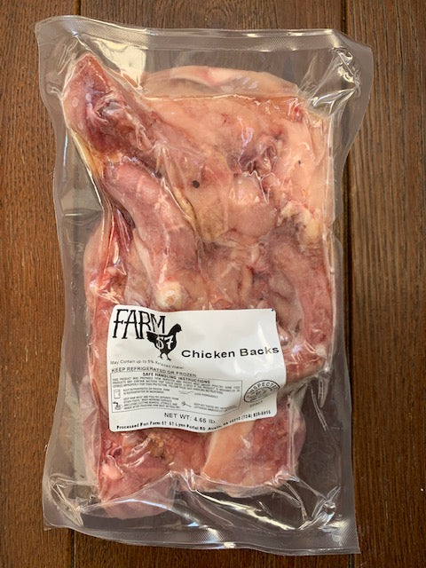 a raw vacuum sealed package of chicken backs on a wood background