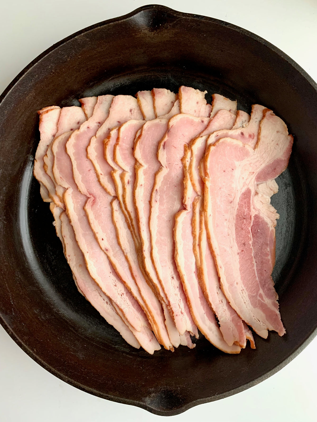 raw bacon in a skillet