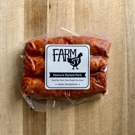 vacuum sealed and frozen pork hot sausage links on wood cutting board