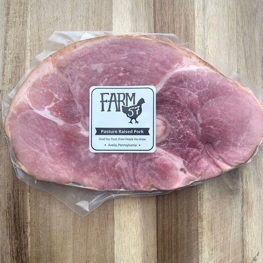 a vacuum sealed and frozen package of one skillet ham slice on a wood cutting board with Farm57 label